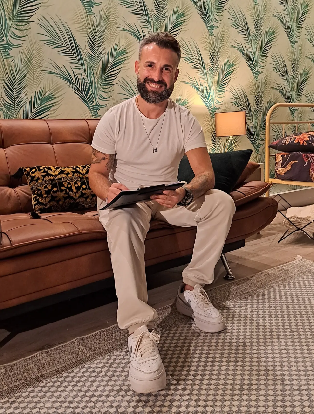 Miguel sorrindo sentado no sofa